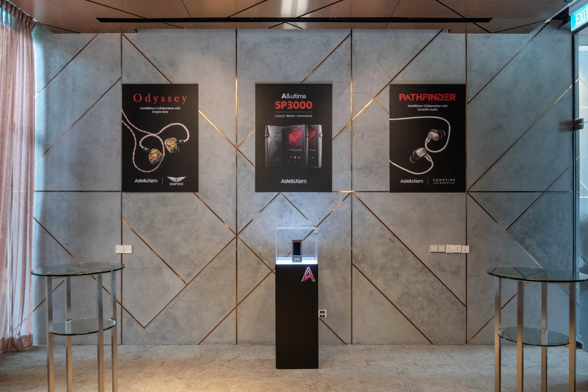 Three larger posters featuring Odyssey, Astell&Kern A&ultima SP3000 and Pathfinder, are displayed on the wall with the SP3000 being physically displayed in an acrylic lightbox right below it's poster.