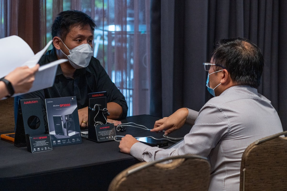Exhibitor and attendee interacting at the Astell&Kern SP3000 and Odyssey media launch event.