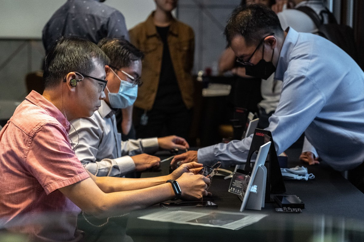 Exhibitor and attendee interacting at the Astell&Kern SP3000 and Odyssey media launch event.