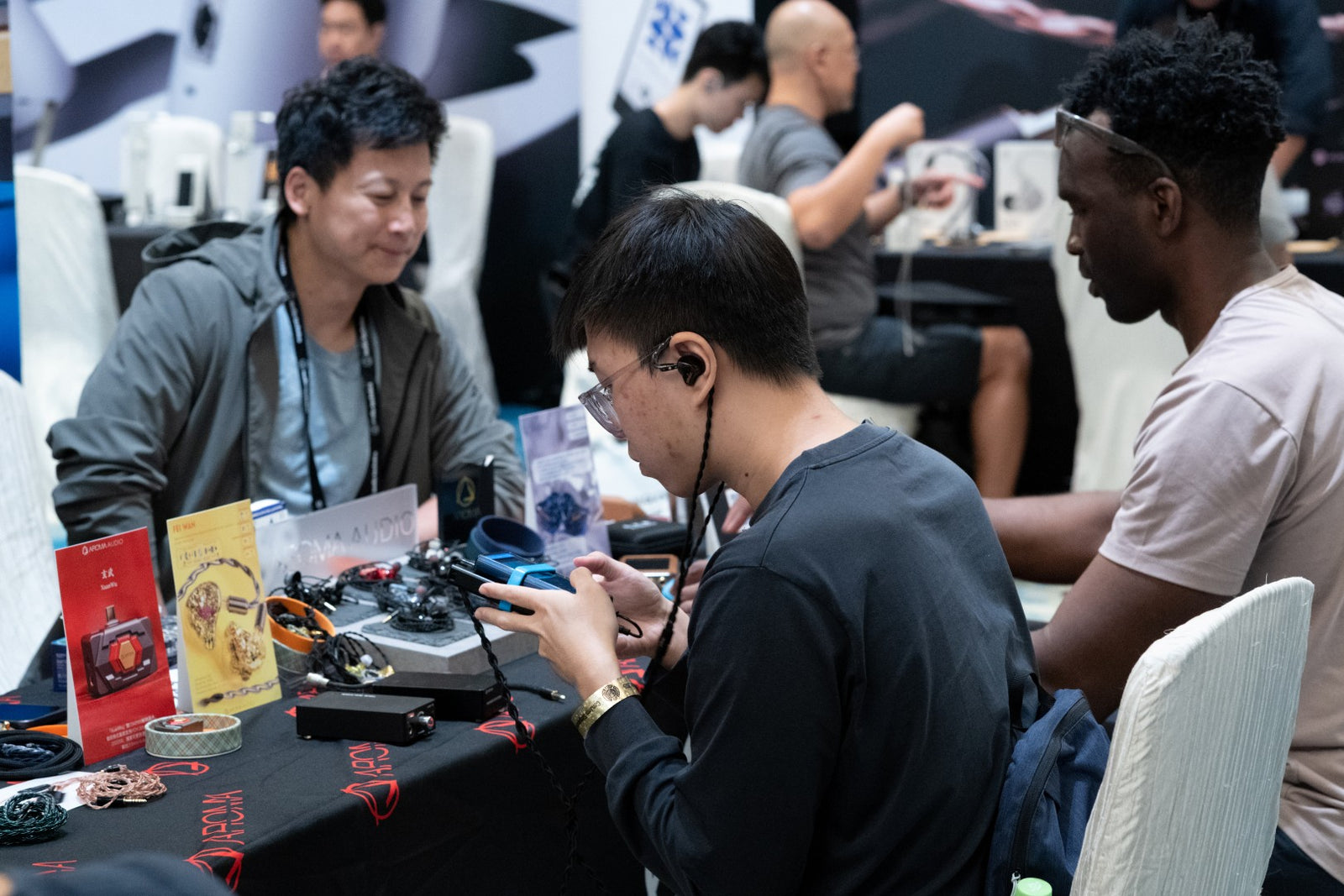 Attendees interacting with the products at the Aroma Audio booth at CanJam Singapore 2025 event.