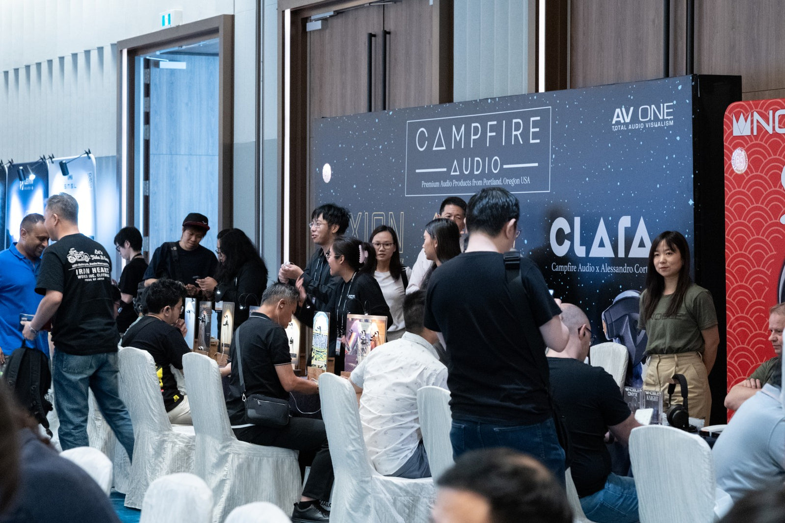Exhibitor and attendees interacting at the Campfire Audio booth at CanJam Singapore 2025 event.