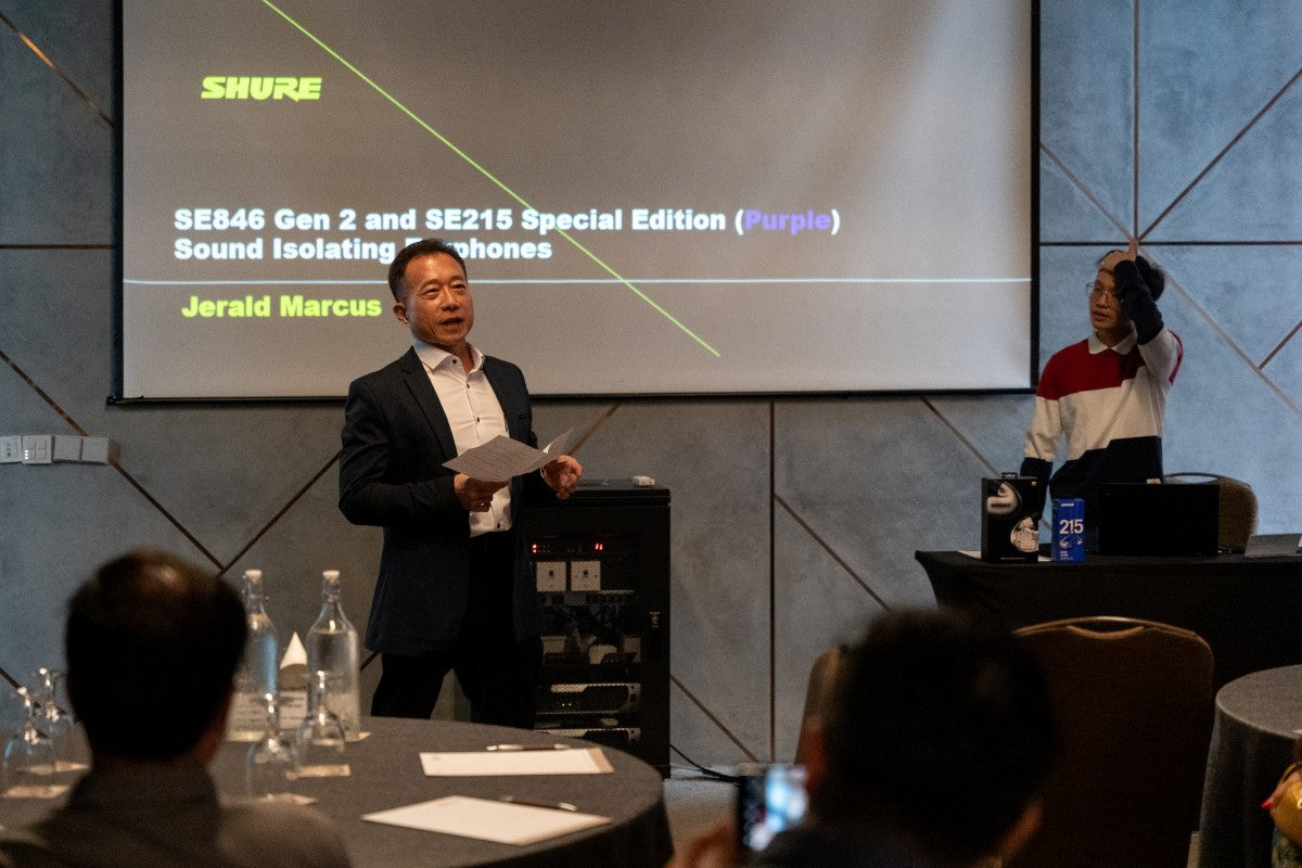 A man presenting to the audience at the Shure SE846 Gen 2 and SE215 Special Edition Purple media launch event.