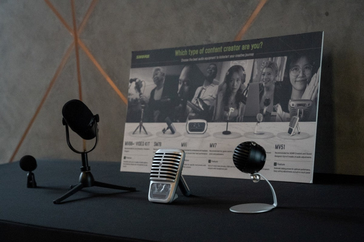 Shure Motiv Microphones (MV88+, SM7B, MV51 and MV5C) on display backed by a poster with the title "Which type of content creator are you?".